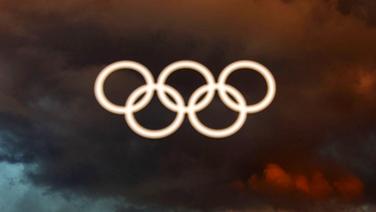 Die Olympischen Ringe vor dunklen Wolken © imago/Xinhua 