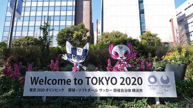 Tokios Olympia-Maskottchen zeigen ein Begrüßungsplakat vor dem Rathaus von Yokohama. © imago images / AFLOSPORT 