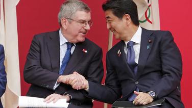 Shinzo Abe, Ministerpräsident von Japan, und IOC-Präsident Thomas Bach (l.) schütteln sich die Hand. © picture alliance/Koji Sasahara/AP/dpa Foto: Koji Sasahara