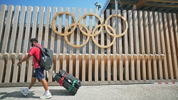 Blick auf einen Zaun mit den olympischen Ringen am Eingang des Olympischen Dorfes in Tokio. © dpa bildfunk Foto: Michael Kappeler