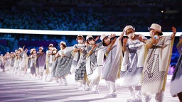 Tänzer und Tänzerinnen in einer Reihe aufgestellt und in Weiß gekleidet © imago images/Xinhua Foto: Li Ming