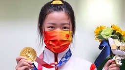 Die chinesische Sportschützin Yang Qian mit der Goldmedaille der Frauen im Schießen mit dem Luftgewehr über 10 Meter. © dpa-Bildfunk Foto: Oliver Weiken/dpa
