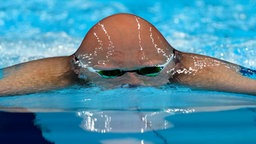Der finnische Schwimmer Matti Mattsson durchbricht die Wasseroberfläche. © dpa-bildfunk