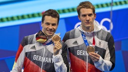 Die deutschen Synchronspringer Patrick Hausding (l.) und Lars Rüdiger präsentieren ihre Bronzemedaillen. © IMAGO / Moritz Müller