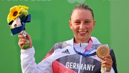 Die deutsche Kanutin Andrea Herzog präsentiert ihre Bronzemedaille bei der Siegerehrung. © dpa-Bildfunk Foto: Jan Woitas/dpa-Zentralbild/dpa