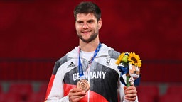 Der deutsche Tischtennis-Spieler Dimitrij Ovtcharov präsentiert seine Bronzemedaille. © dpa-Bildfunk Foto: Marijan Murat/dpa