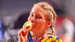 Die deutsche Ringerin Aline Rotter-Focken präsentiert ihre Goldmedaille. © IMAGO / Sven Simon