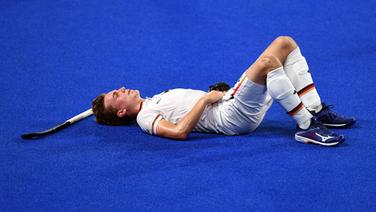 Der deutsche Hockeyspieler Niklas Bosserhoff liegt enttäuscht und erschöpft auf dem Boden © dpd-bildfunk 