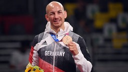 Der deutsche Ringer Frank Stäbler präsentiert seine Bronzemedaille. © IMAGO / Sven Simon Foto:  Frank Hoermann