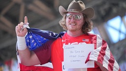 Ryan Crouser aus den USA jubelt mit Cowboyhut und Nationalflagge. © dpa-bildfunk Foto:  Michael Kappeler