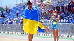 Die ukrainische Kanutin Liudmyla Lusan springt ihrem Trainer vor Freude über Bronze in die Arme. © IMAGO / Sven Simon