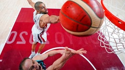 Der französische Basketball-Spieler Nicolas Batum (oben) blockt einen Korbeleger von Sloweniens Klemen Prepelic. © dpa-Bildfunk Foto: Charlie Neibergall/Pool AP/dpa