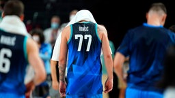Der slowenische Basketball-Spieler Luka Doncic verlässt das Spielfeld mit einem Handtuch auf dem Kopf. © dpa-Bildfunk Foto: Charlie Neibergall/AP/dpa