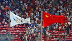 Die chinesische Flagge weht neben der Flagge mit den Olympischen Ringen. © picture-alliance / Xinhua | Xing Guangli 