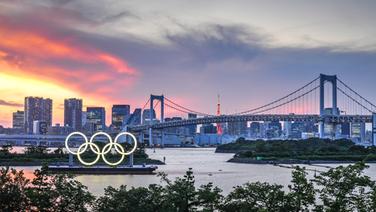 Ein Blick auf olympischen Ringe vor der Rainbow Bridge bei Sonnenuntergang. © dpa-Bildfunk Foto: Yang Lei/XinHua/dpa