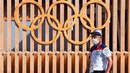 Ein Mann steht vor dem Olympischen Dorf © Witters Foto: DanielStiller