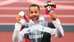 Der deutsche Prothesensprinter Leon Schäfer präsentiert sein Bronzemedaille über 100 Meter. © IMAGO / Beautiful Sports