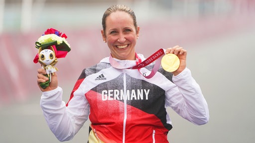Die deutsche Para-Radsportlerin Annika Zeyen präsentiert ihre Goldmedaille.