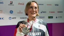 Die Sportschützin Natascha Hiltrop nach der Siegerehrung mit der Medaille. © ARD/screenshot 