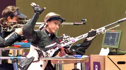 Sportschützin Natascha Hiltrop hebt im 50-Meter-Wettbewerb mit dem Kleinkaliber-Gewehr bei den Paralympics in Tokio ihren rechten Arm. © NDR 