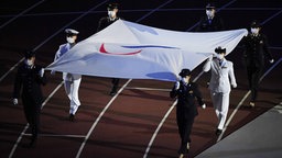Die Paralympische Flagge wird zum Mast getragen © imago images/SNA Foto: Pavel Bednyakov