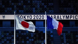 Die Flaggen Japans und Frankreichs wehen während der Abschlusszeremonie der Paralympics in Tokio. © imago images/SNA Foto: Pavel Bednyakov