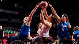 Die niederländische Rollstuhlbasketballerin Mariska Beijer (M.) in Aktion gegen die US-Amerikanerinnen Rose Hollermann (l.) und Natalie Schneider. © IMAGO / Beautiful Sports