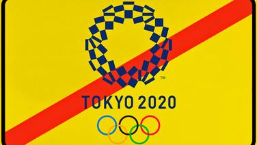 Ein gelbes Schild mit durchgestrichenen Olympia-Schriftzug Tokio 2020. © imago images / Michael Weber 