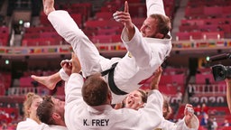 Das deutsche Mixed-Team der Judoka um Sebastian Seidl (oben) jubelt über Bronze. © dpa-Bildfunk Foto: Friso Gentsch/dpa