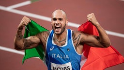 Der 100m Läufer Lamont Marcell Jacobs aus Italien jubelt mit der Nationalflagge. © imago images/Bildbyran 