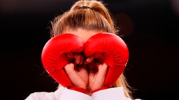 Die ukrainische Karateka Anschelika Terliuga formt mir ihren Handschuhen ein Herz. © IMAGO / Agencia EFE